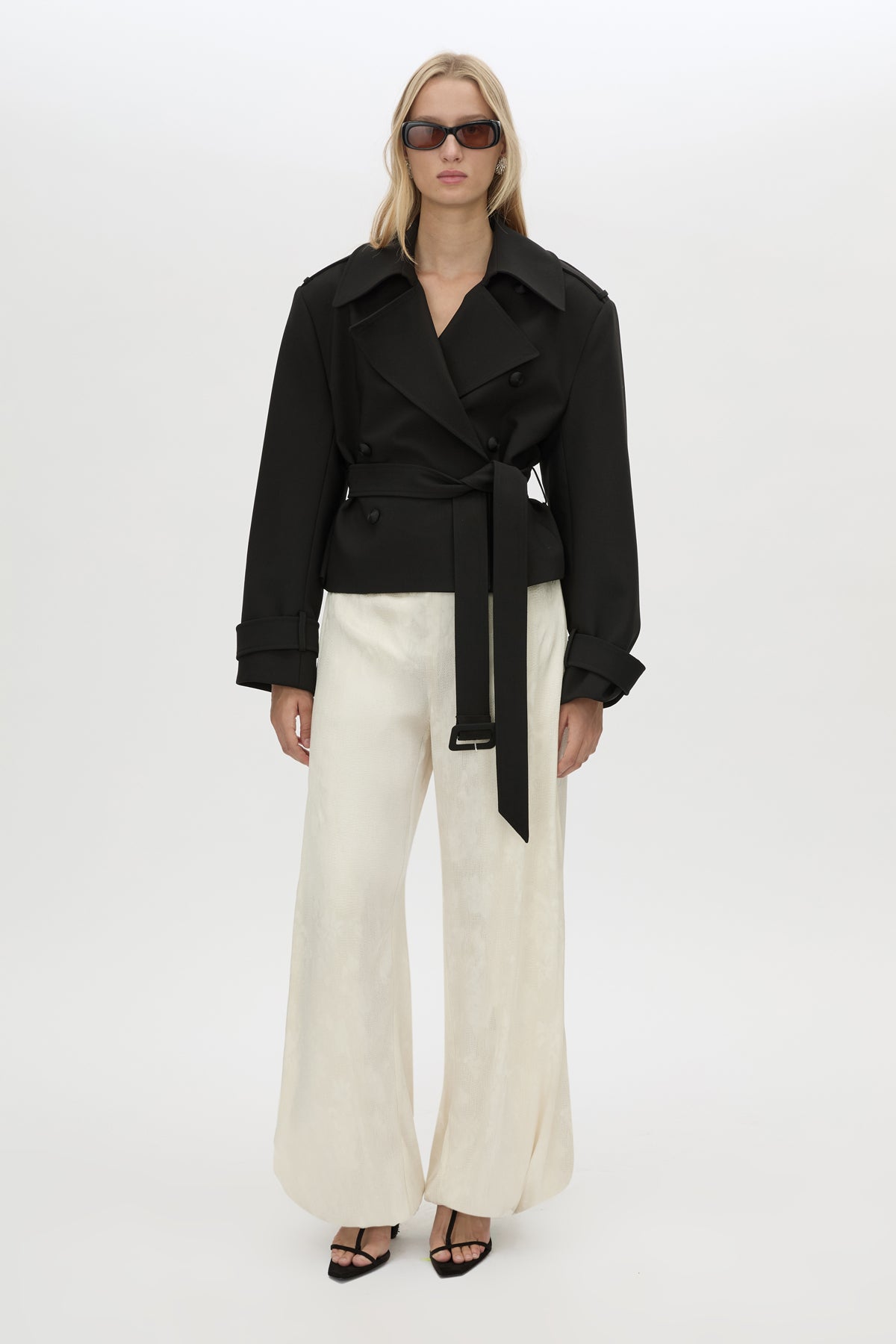 Front-styled view CAMILLA AND MARC cropped Asena Short Trench in black with double breasted closure.