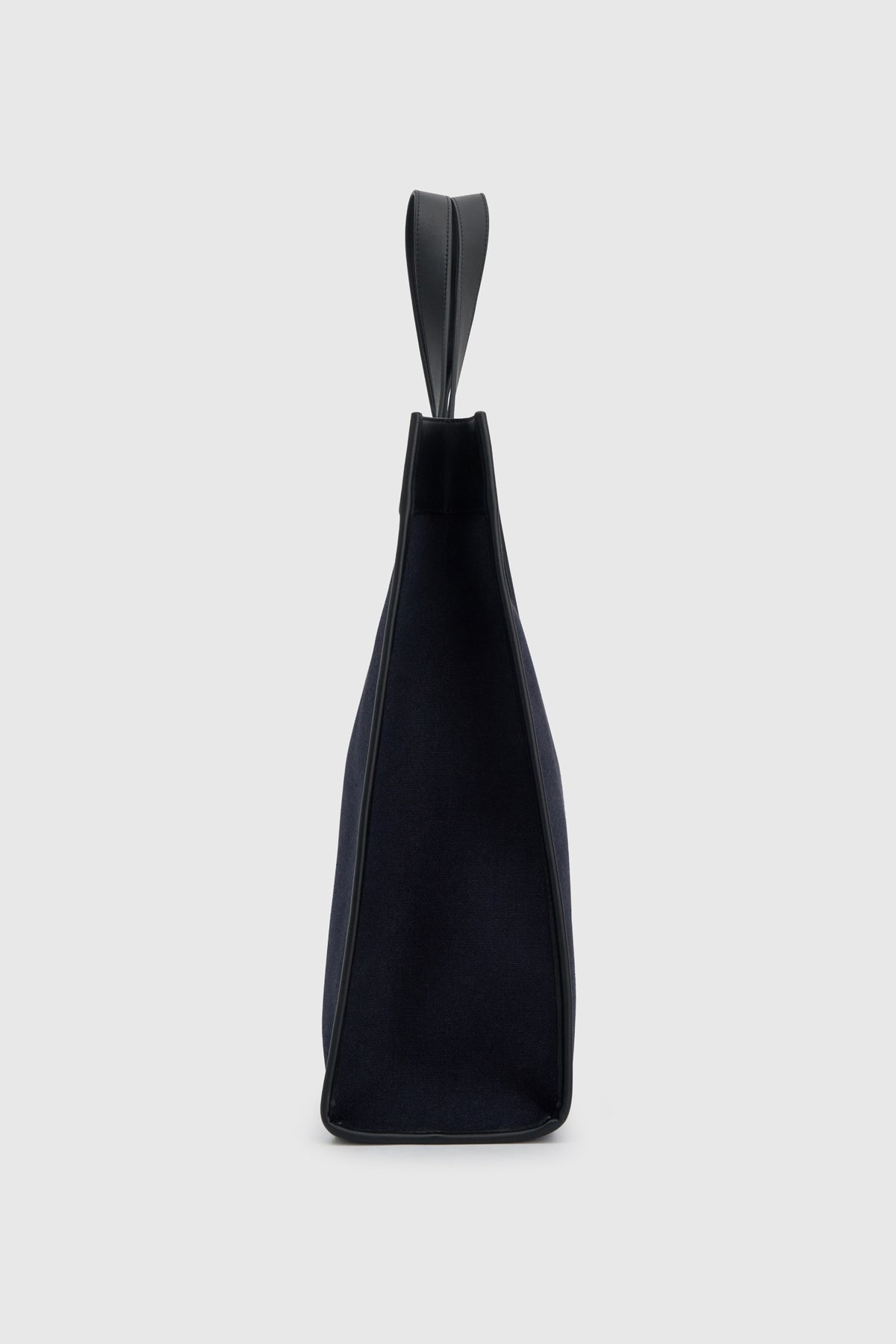 Side view CAMILLA AND MARC August Tote Bag in navy with black trim in cotton-linen canvas.