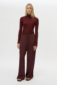 Front view CAMILLA AND MARC Barre High Neck Top in Burgundy styled with the Ground Satin Pant.