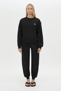 Front styled view CAMILLA AND MARC Bonnie relaxed logo track pant in black with elasticated drawcord waistband.