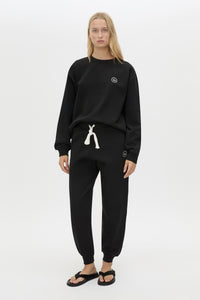 Front view CAMILLA AND MARC Bonnie relaxed logo track pant in black with elasticated drawcord waistband.