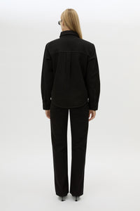 Back view CAMILLA AND MARC Caden Denim Shirt in True Black with shoulder pads and embroidered monogram detailing.