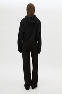 Back view CAMILLA AND MARC Carmont Graphic Hoodie in Black with boxy fit and black graphic logo.