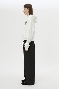 Side view CAMILLA AND MARC Carmont Graphic Hoodie in Soft White with boxy fit and black graphic logo.