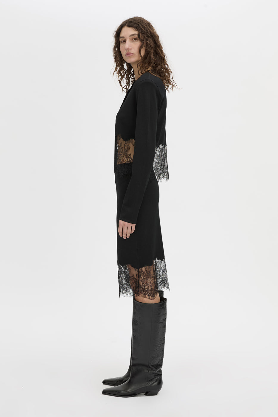 Side view CAMILLA AND MARC Cayana Lace Knit Skirt in black with knit knee length design and lace hem detail.