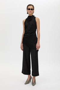 Front styled view CAMILLA AND MARC Dune Fringe Top in Black with asymmetric cut, gathered waist, high neck and fringe scarf.