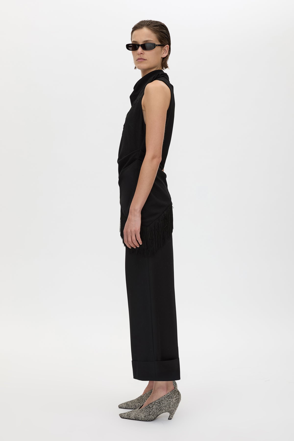 Side view CAMILLA AND MARC Dune Fringe Top in Black with asymmetric cut, gathered waist, high neck and fringe scarf.