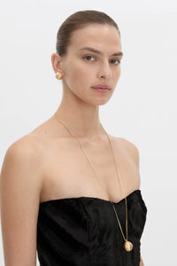 Side view CAMILLA AND MARC Eagan Pendant in gold with fine box chain and ruched textured sphere pendant.
