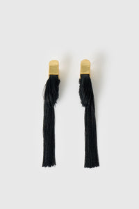 Front view CAMILLA AND MARC Friesian Drop Earrings with 18k gold plating, featuring draped black tassel drop fringing.