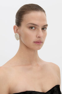 Side view CAMILLA AND MARC Irida Earrings in cream with spiral pearl design.