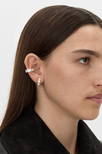 Styled view CAMILLA AND MARC Leighton Huggies in 18k gold finish with emerald cut cubic zirconia stones.