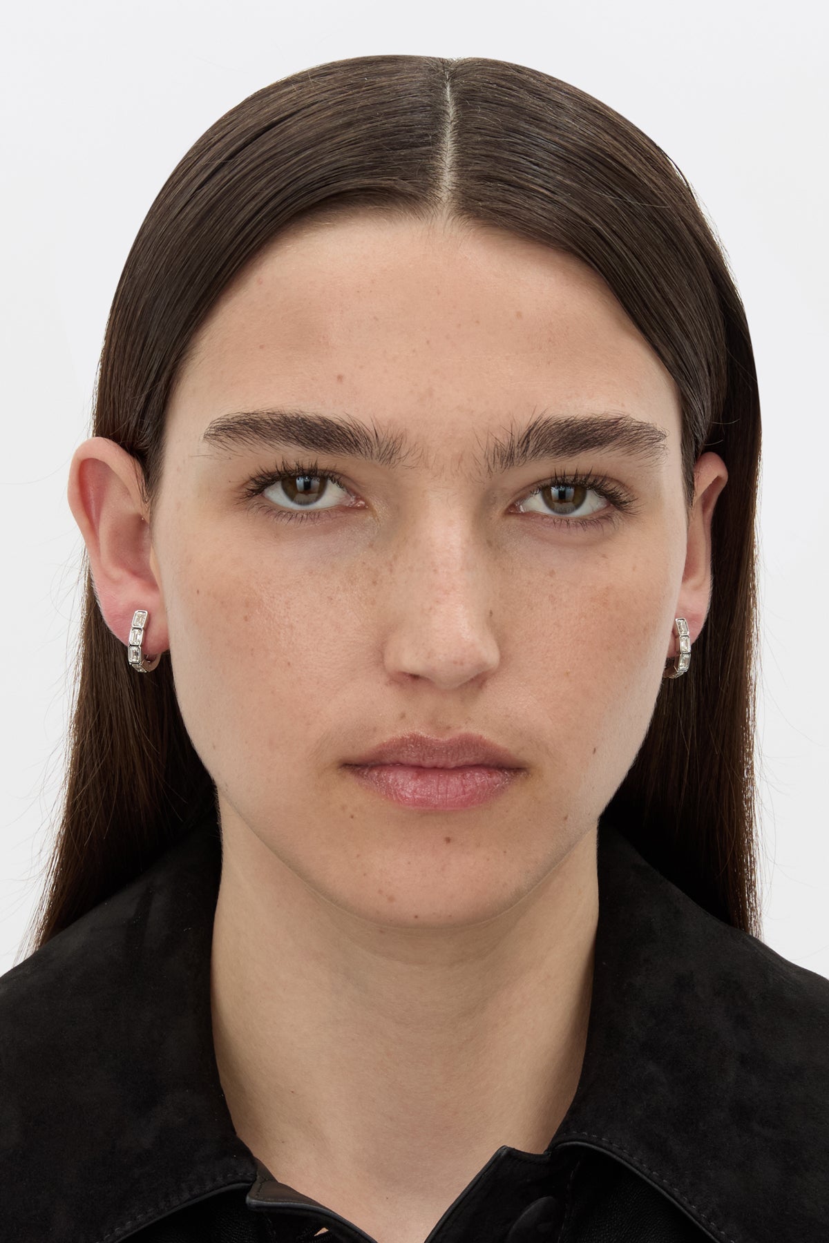 Front-styled view CAMILLA AND MARC Leighton Huggies in silver finish with emerald cut cubic zirconia stones.