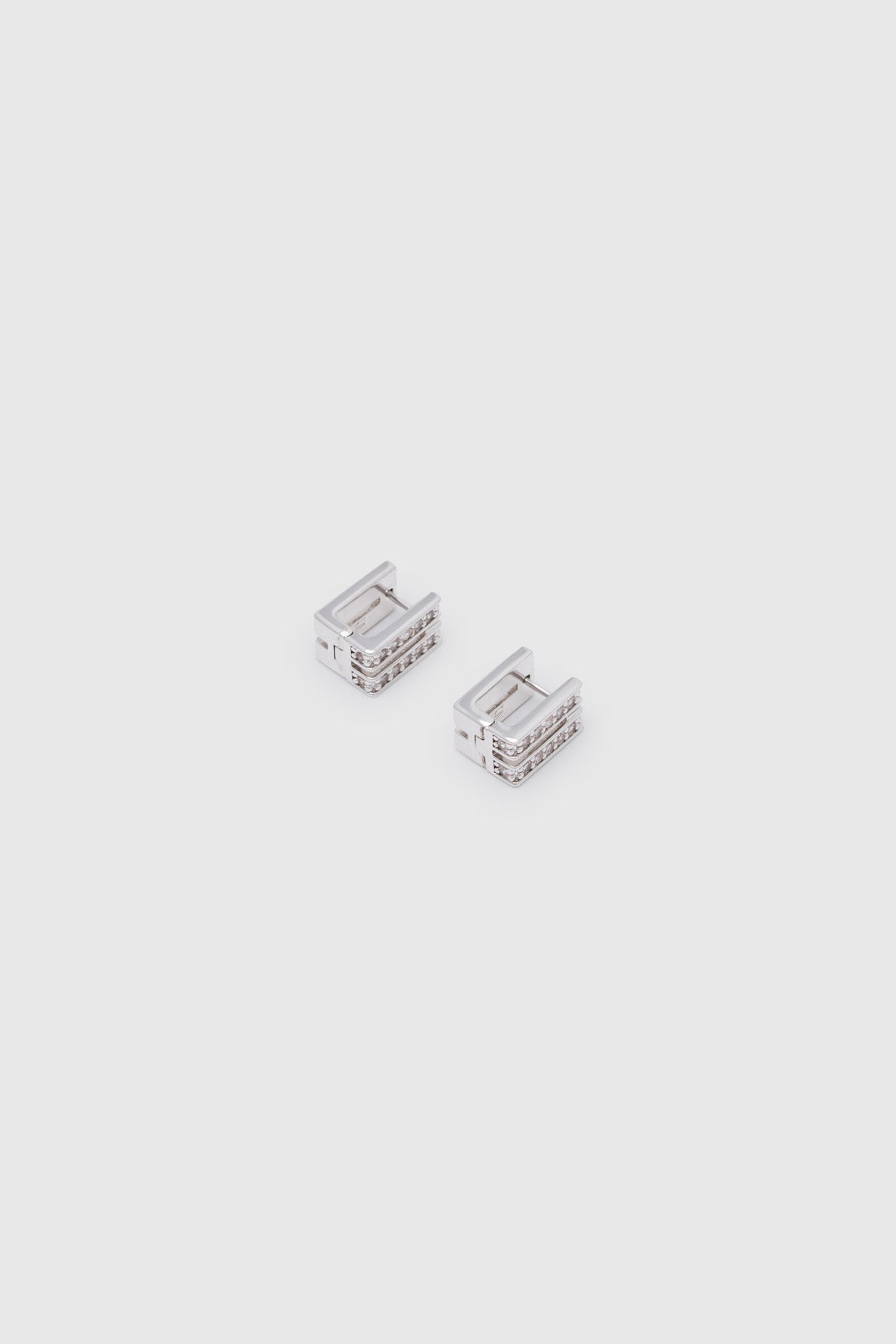 Ghost view CAMILLA AND MARC Leighton Pavé Huggies in silver with double‑row pavé cubic zirconia detailing.