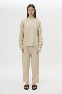 Front styled view CAMILLA AND MARC Lloyd Sweater in Cream with a ribbed turtleneck and an embroidered chest monogram.