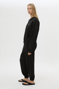 Side view CAMILLA AND MARC Lyra Logo Track Pant in Black and White with relaxed fit and embroidered initial detail.