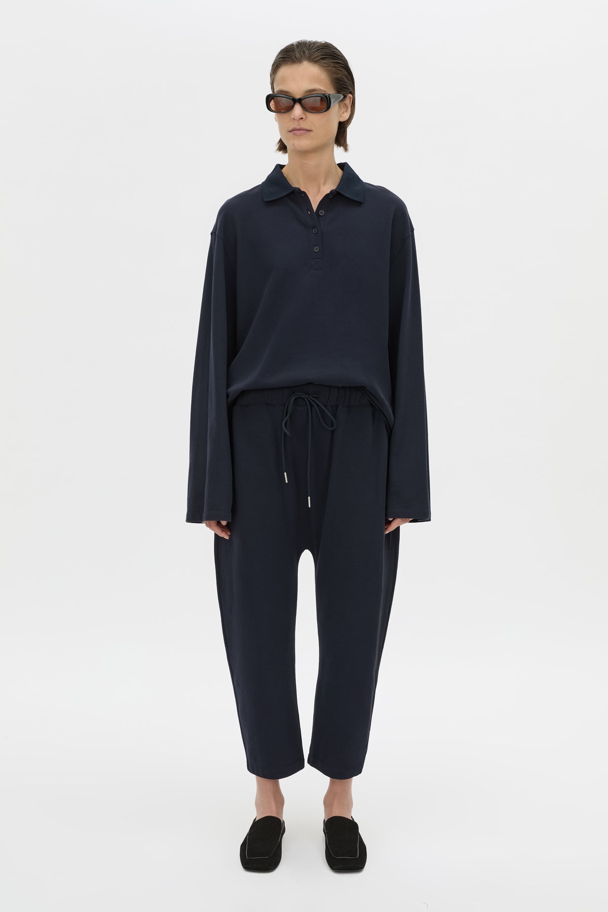 Front styled view CAMILLA AND MARC Moreno Pique Track Pant in navy with elastic‑encased waistband and embroidered eyelets and drawcord.