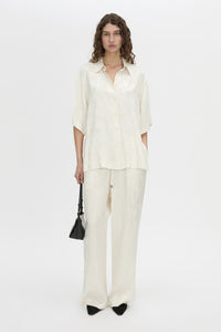 Front-styled view CAMILLA AND MARC Naidee Satin Short Sleeve Shirt in ivory white.