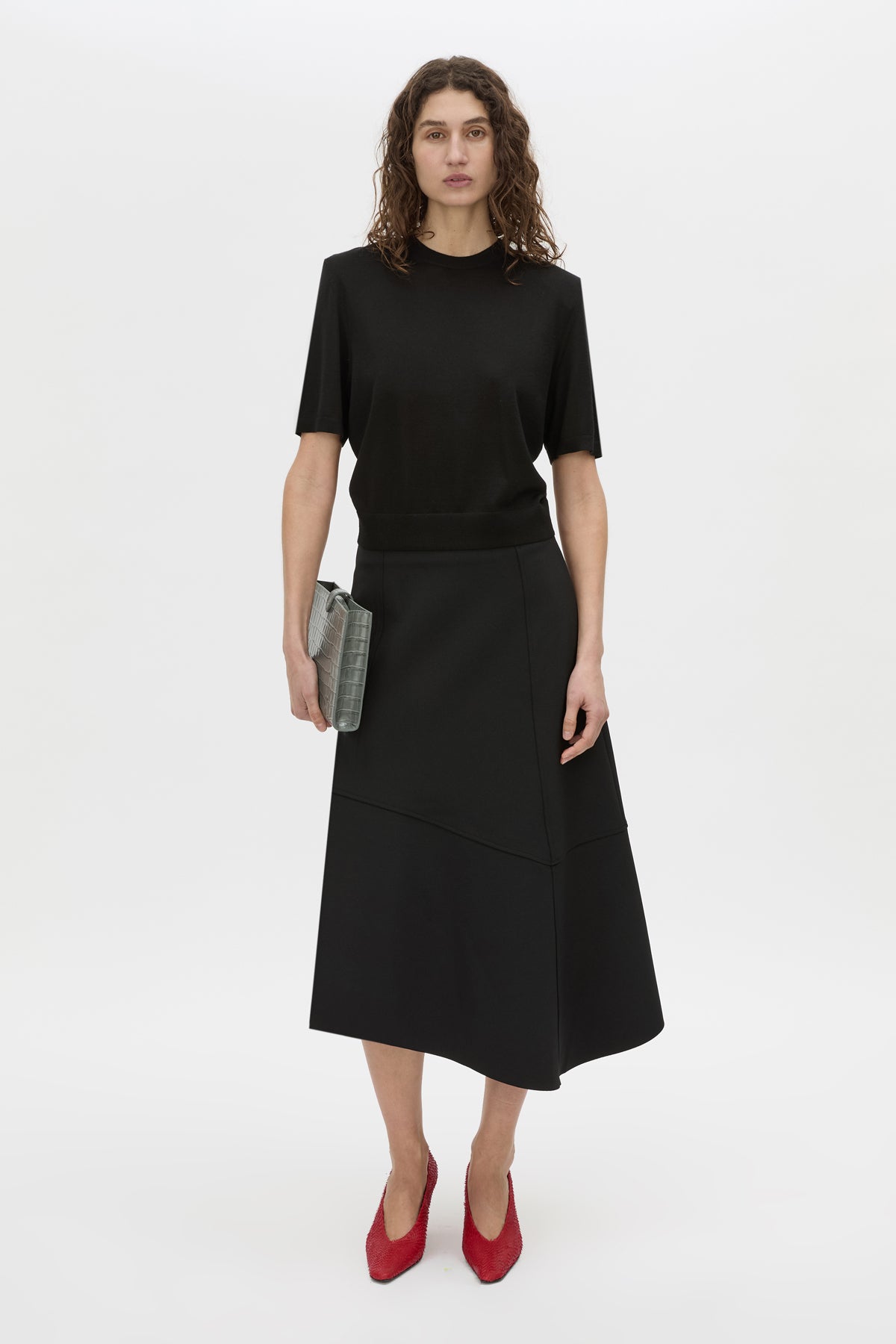 Styled view CAMILLA AND MARC high-waisted Namira Midi Skirt in black with asymmetric hemline.