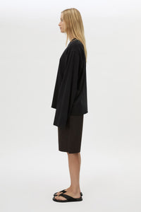 Side view with shorts CAMILLA AND MARC Peretti Long Sleeve Tee in Black with wide shaped sleeves.  