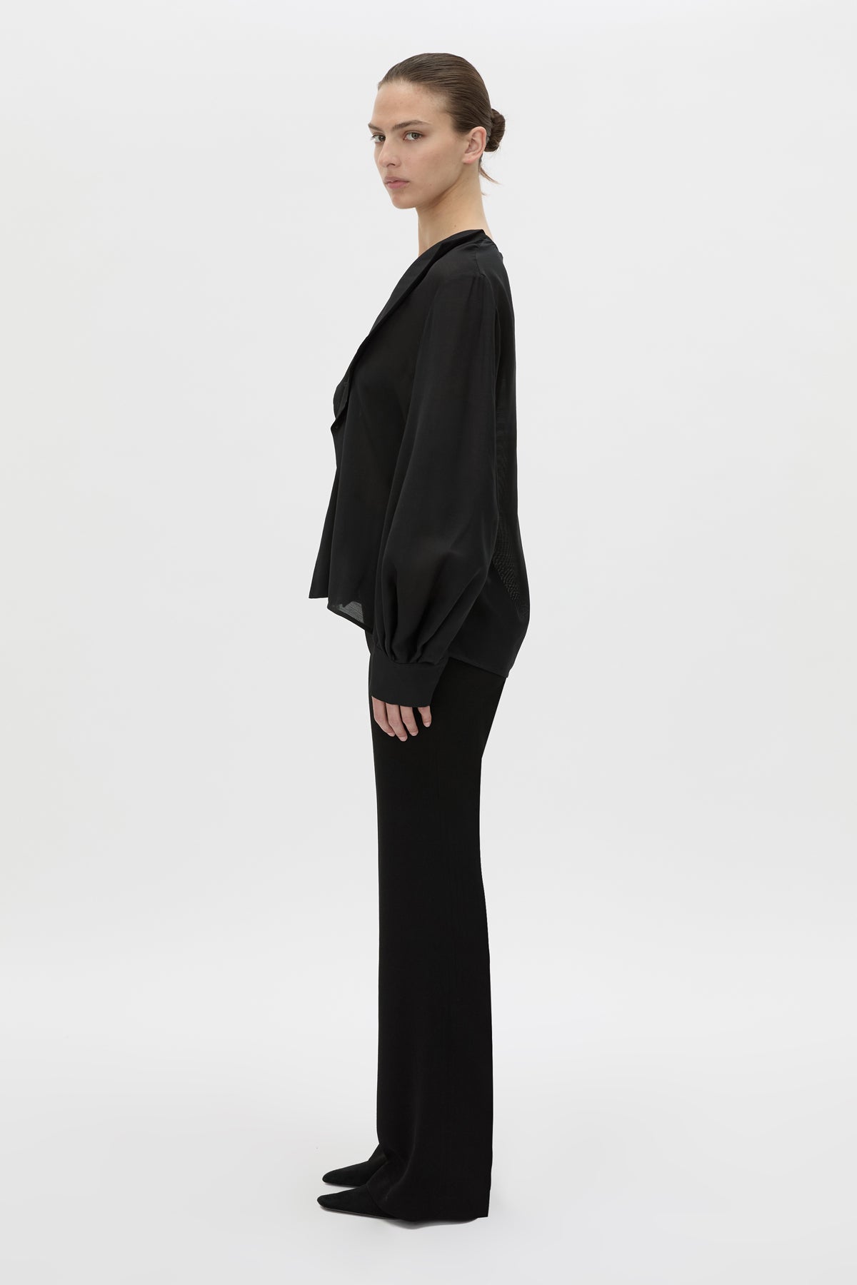 Side view CAMILLA AND MARC Rene Long Sleeve Top in black with adjustable neckline and blouson sleeves.