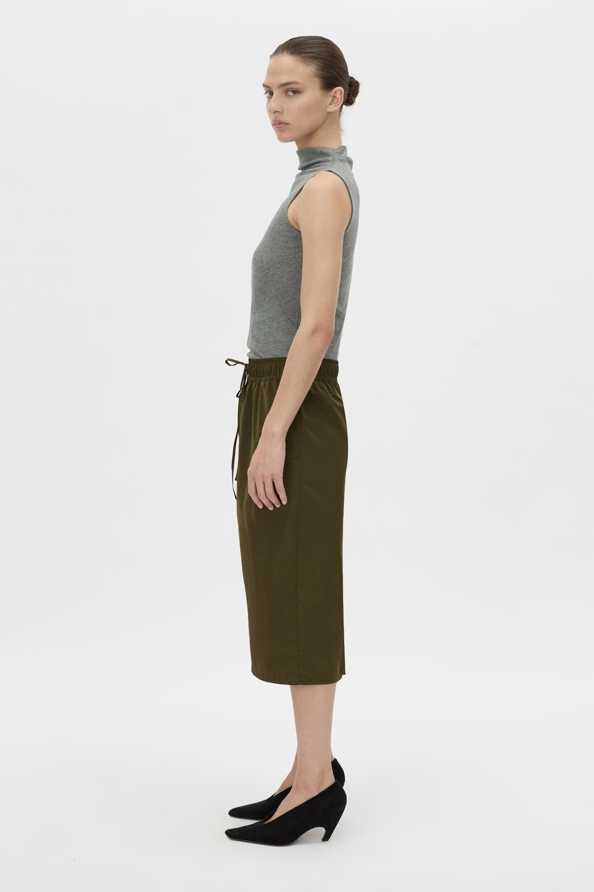Side view CAMILLA AND MARC Storm Midi Skirt in khaki with an elasticated waistband, slanted side pockets and a back vent.