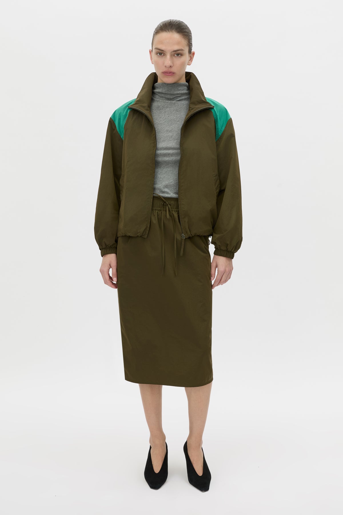 Styled view CAMILLA AND MARC Storm Midi Skirt in khaki with an elasticated waistband, slanted side pockets and a back vent.