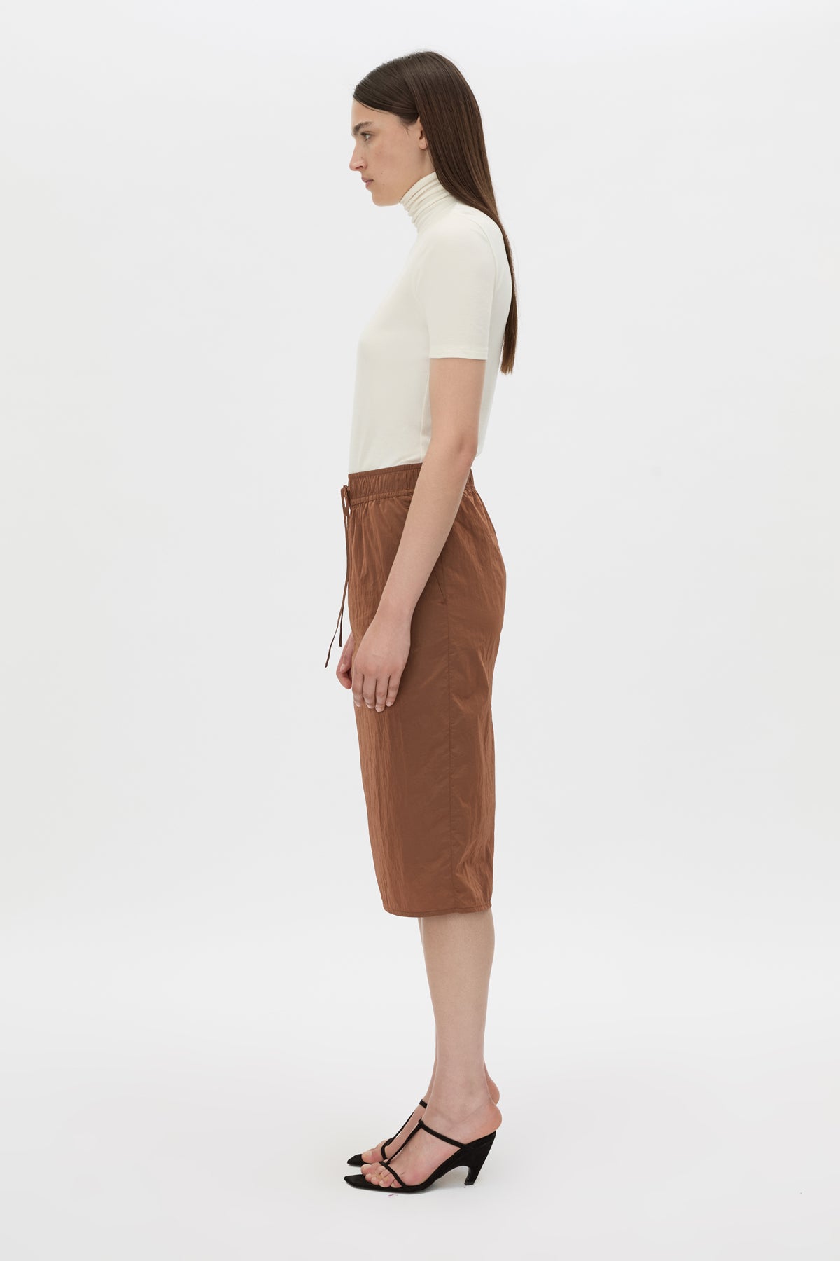 Side view CAMILLA AND MARC Storm Midi Skirt in mocha with an elasticated waistband, slanted side pockets and a back vent.