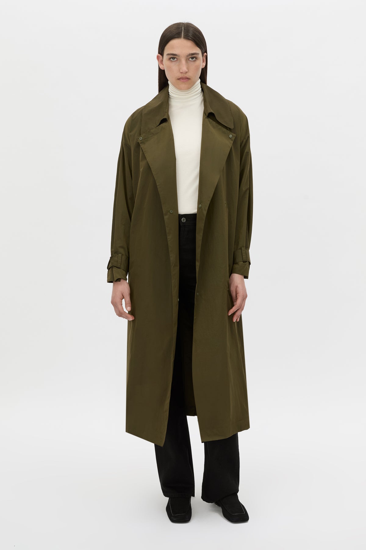 Front-styled view CAMILLA AND MARC Storm Trench Coat in khaki with concealed snap fastenings, in seam pockets and a self tie belt with sleeve straps.