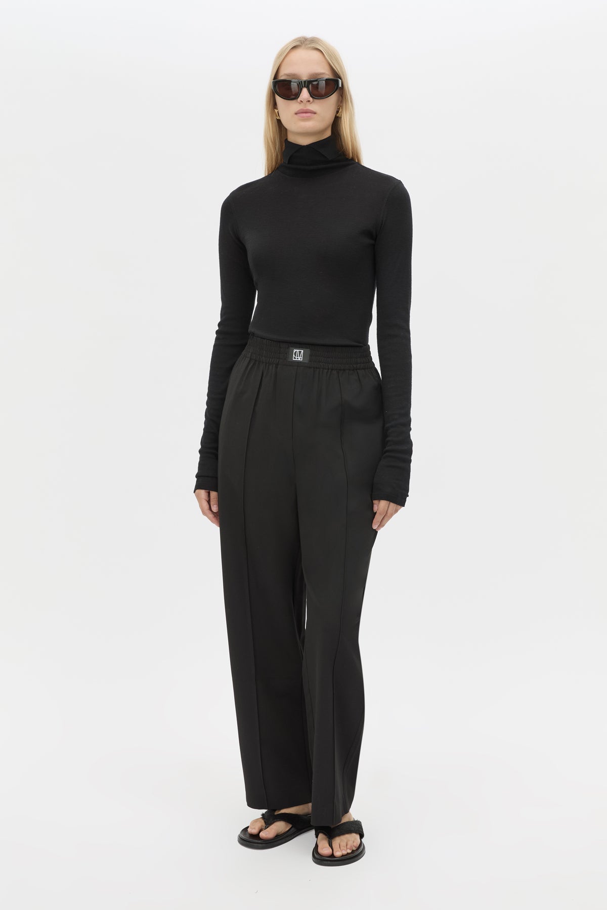 Front view CAMILLA AND MARC Sylvia soft suiting high-waisted pant in black with monogram patch at waistband.