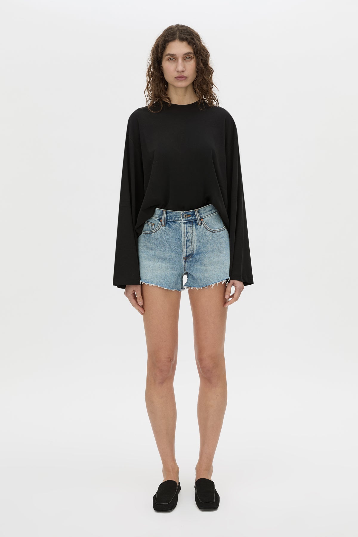 Front-styled-2 view CAMILLA AND MARC Tanner Denim Mini Short in light blue with raw‑hem.