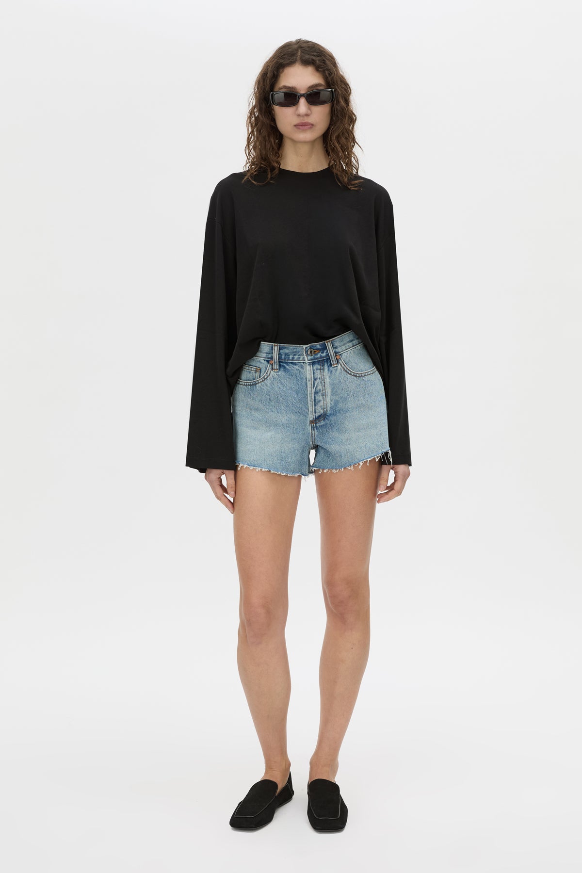 Front-styled view CAMILLA AND MARC Tanner Denim Mini Short in light blue with raw‑hem.