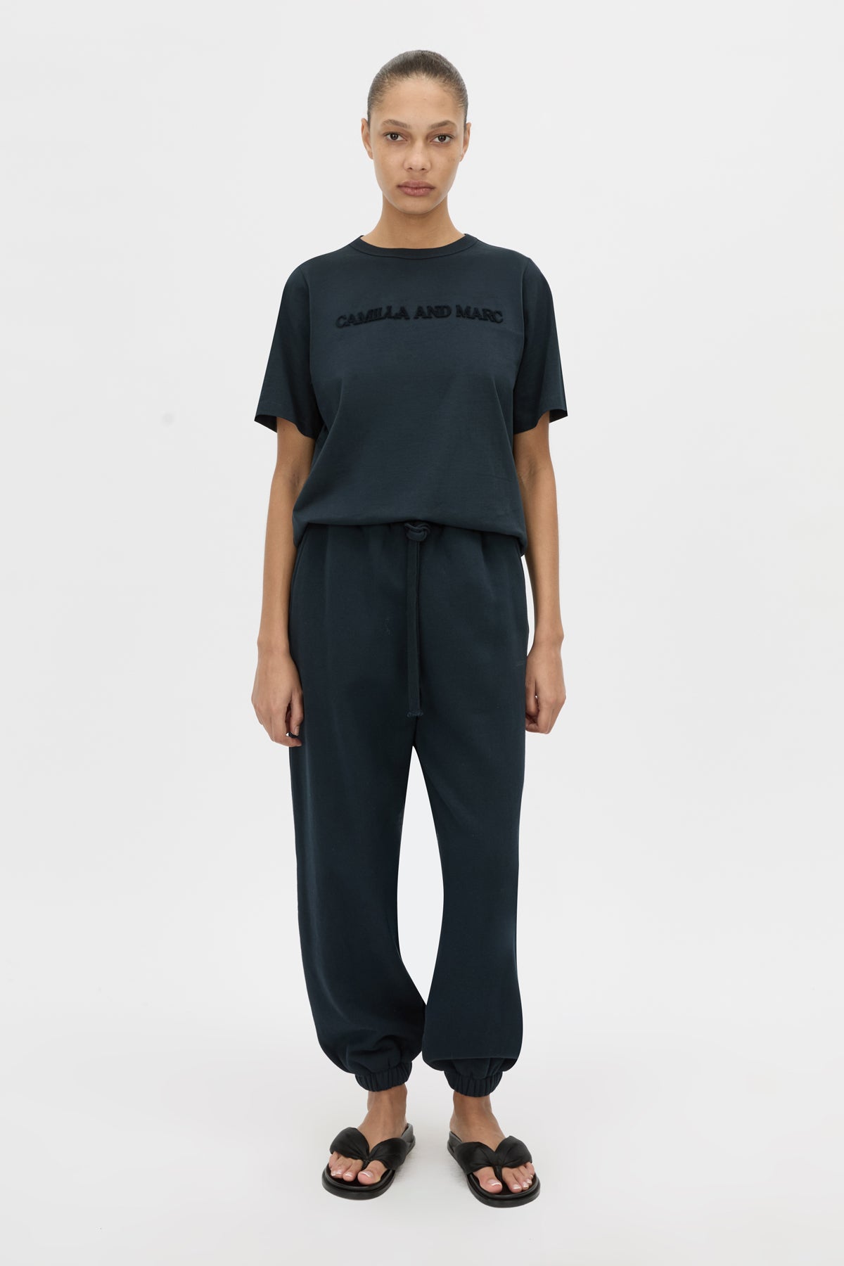 Front-styled view CAMILLA AND MARC relaxed Tia Flocking Logo Tee in deep ink with flocked CAMILLA AND MARC artwork.