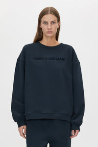 Cropped view CAMILLA AND MARC Tia Flocking Logo Crew in Deep Ink with relaxed fit, logo artwork and 100% cotton.