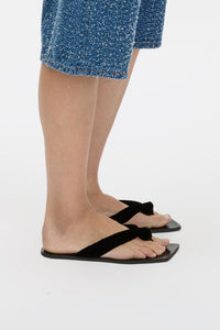 Styled side view CAMILLA AND MARC Liv Velvet Sandal in black with slip‑on design and knotted velvet toe.