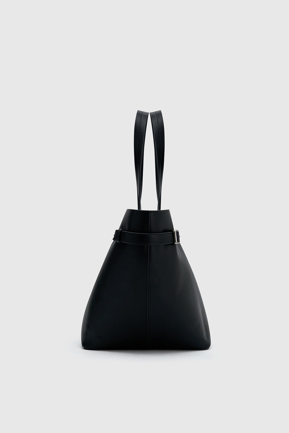 Side view CAMILLA AND MARC Willa Tote in Black with side strap and buckle detailing and magnetic button closure.