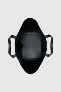 Top view CAMILLA AND MARC Willa Tote in Black with side strap and buckle detailing and magnetic button closure.