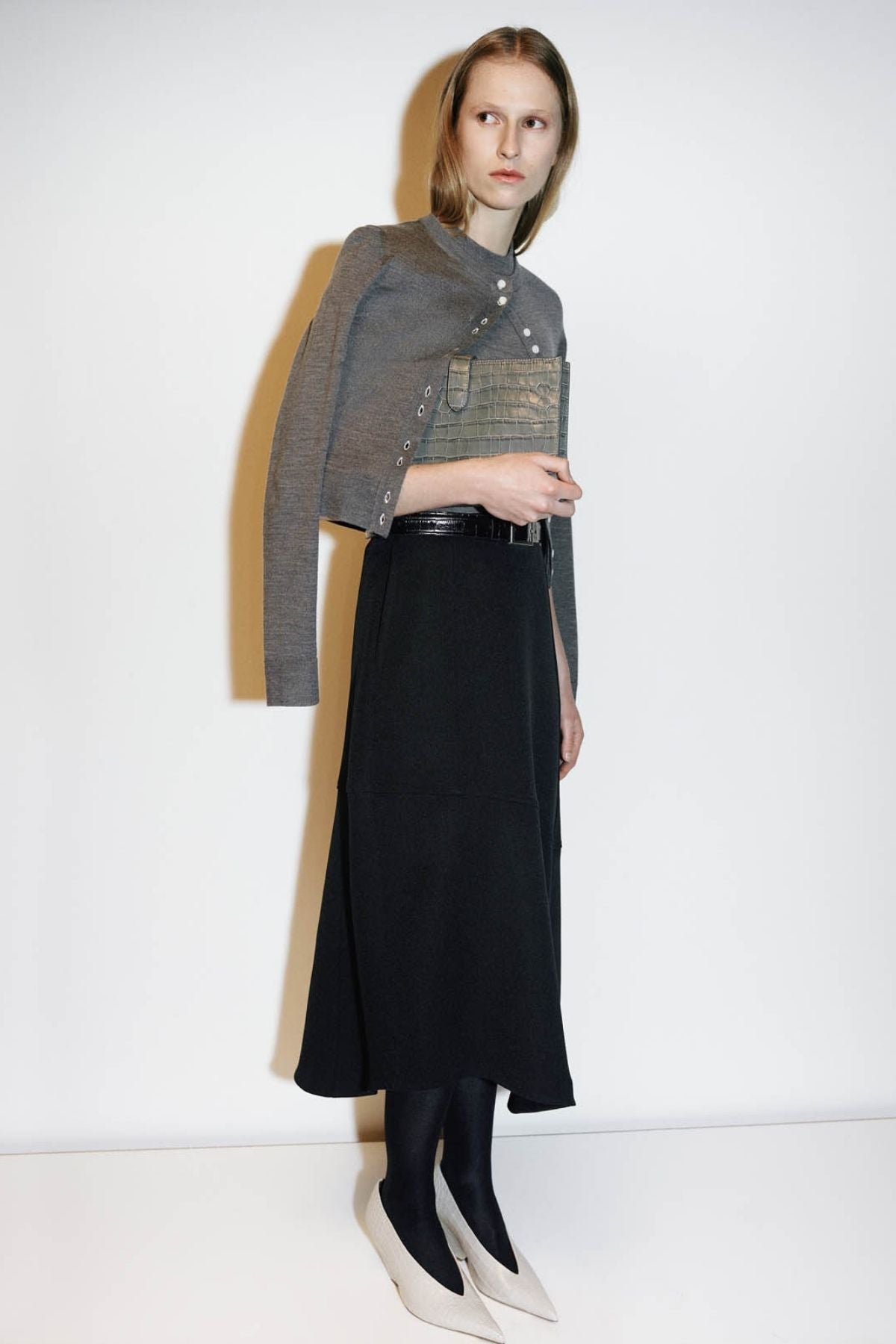 Campaign view CAMILLA AND MARC high-waisted Namira Midi Skirt in black with asymmetric hemline.