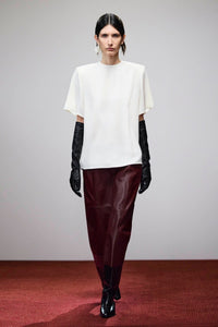 Campaign view CAMILLA AND MARC Orrin Midi Leather Skirt in burgundy with raw asymmetric hemline.